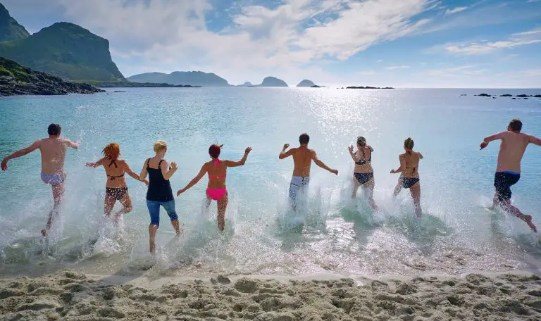 How do travel agencies make money? group of people playing on beach