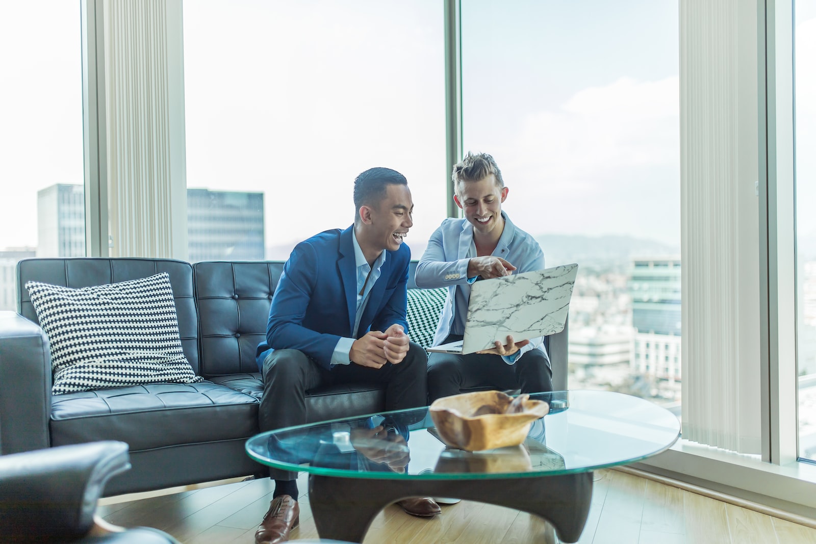 How do real estate agents make money? two men in suit sitting on sofa