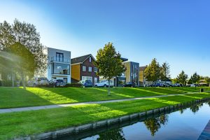 All about property. white and brown house near green grass field and body of water during daytime