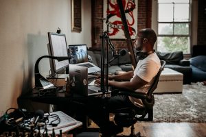 How do podcasters make money? man in white t-shirt sitting on black office rolling chair