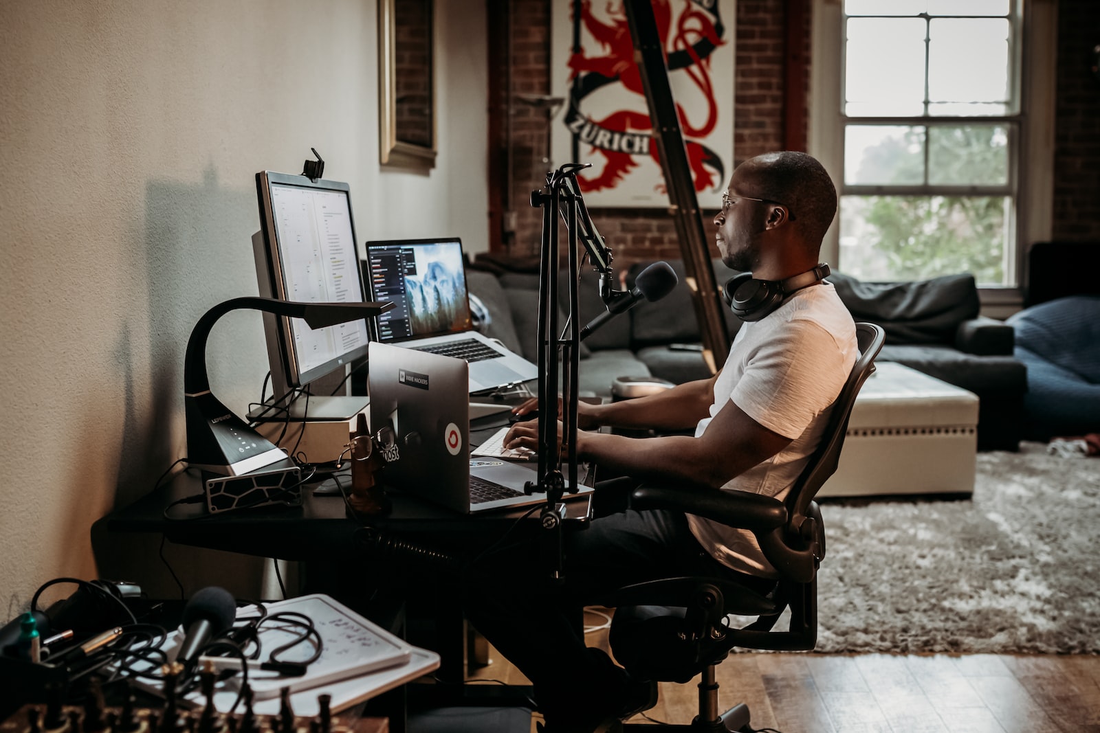 How do podcasters make money? man in white t-shirt sitting on black office rolling chair