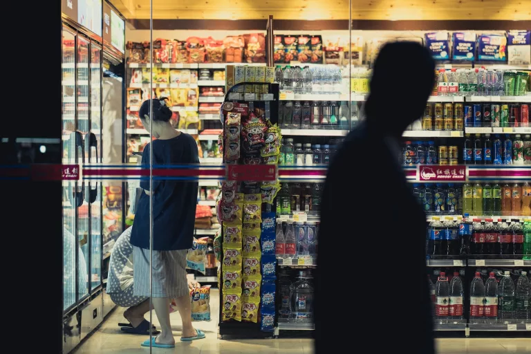 How do convenience stores make money? man and woman standing in front of store