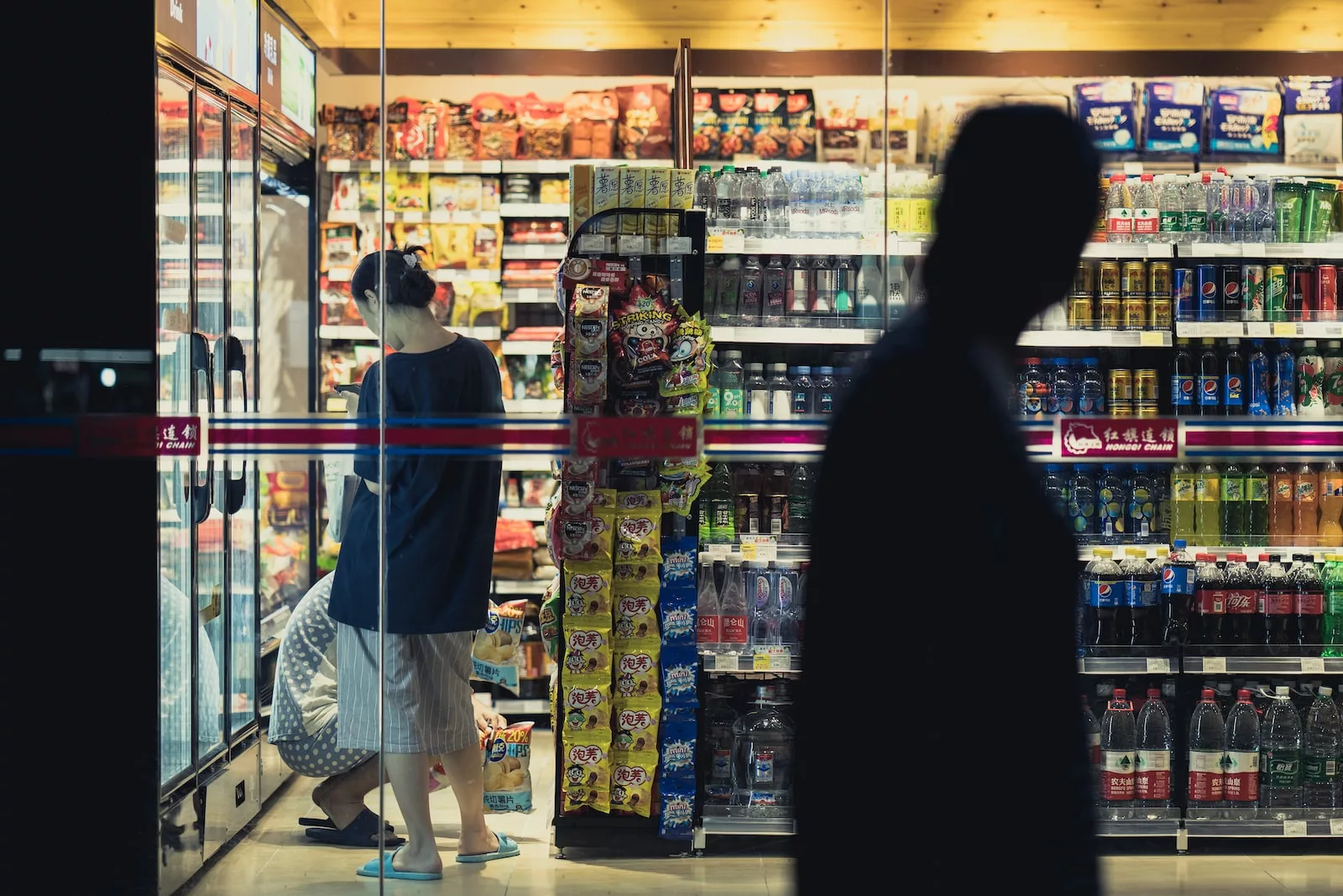 How do convenience stores make money? man and woman standing in front of store